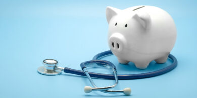 A piggy bank sits on top of a stethoscope.