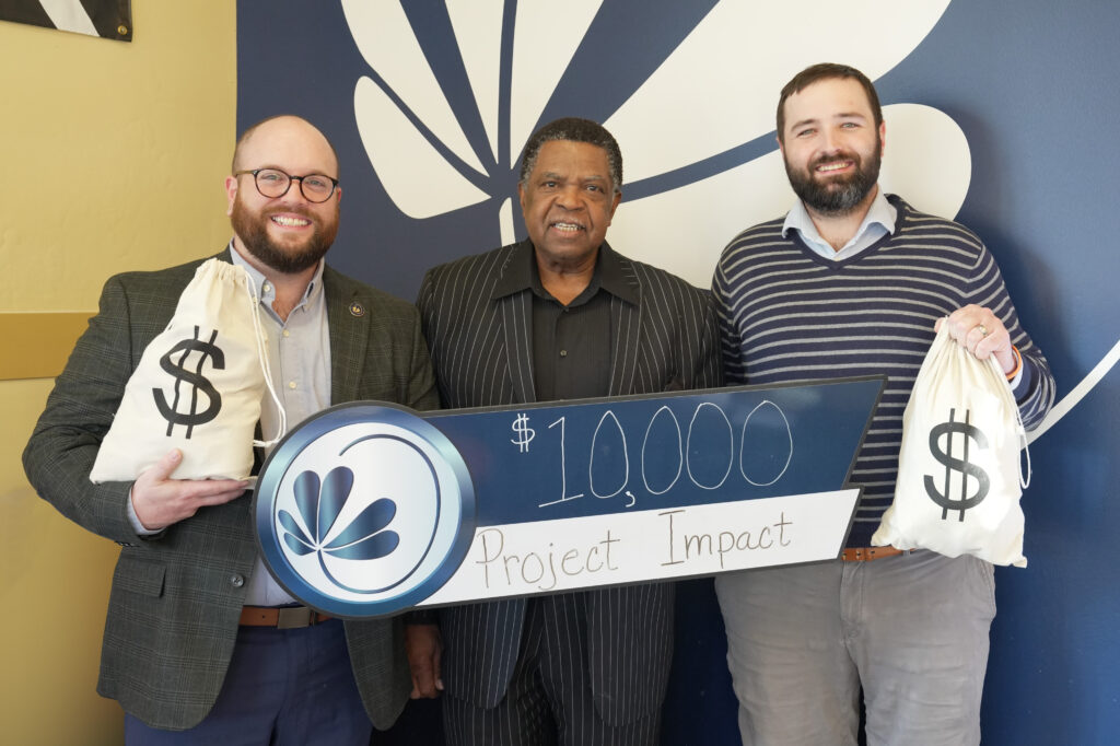 Three gentlemen post for a $10,000 check presentation to Project Impact.