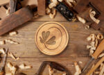 Notre Dame FCU logo pressed into a woodblock surrounded by wood shavings
